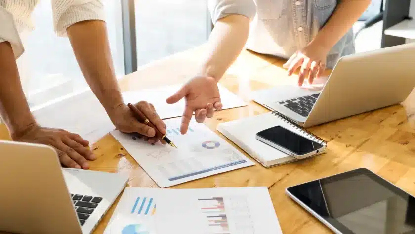 relatorio-de-producao-diaria-mesa-de-trabalho-com-relatorios-e-pessoas-ao-redor
