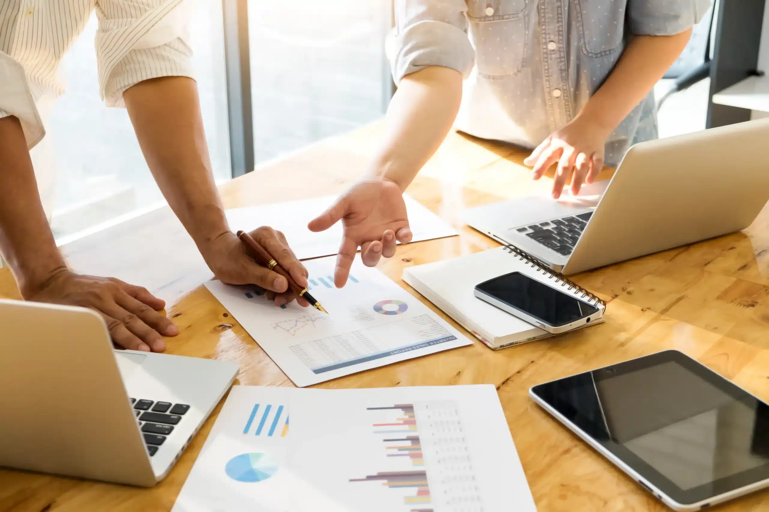 relatorio-de-producao-diaria-mesa-de-trabalho-com-relatorios-e-pessoas-ao-redor