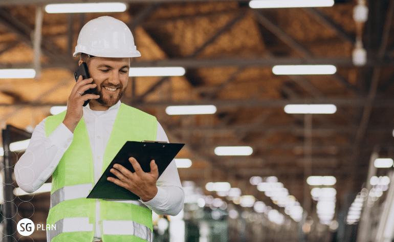 gestor de produção industrial com uma prancheta na mão e falando no celular