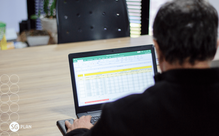gestor atualizando a planilha excel no notebook