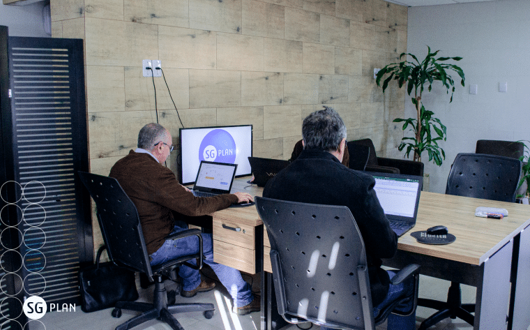 gestores utilizando software de gestão no notebook