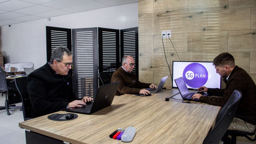 três homens realizando o business intelligence em seus notebooks