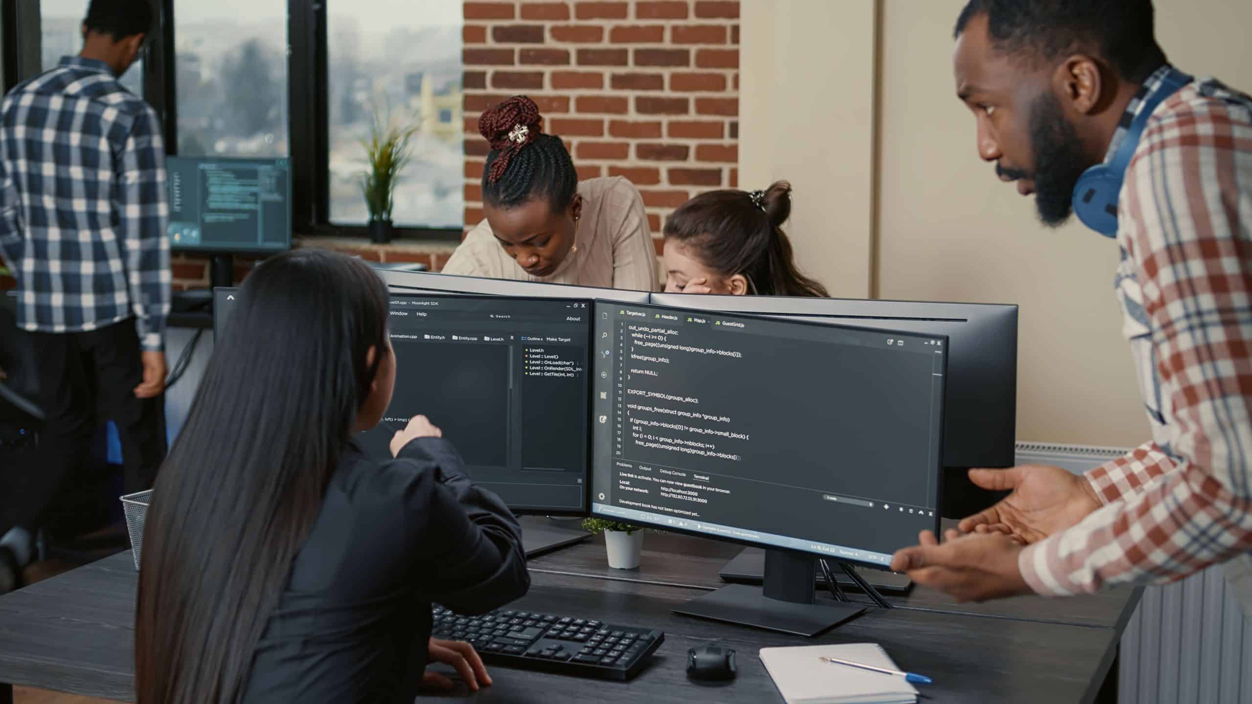 vale-a-pena-investir-em-ti-programadores-trabalhando-em-uma-sala-com-telas