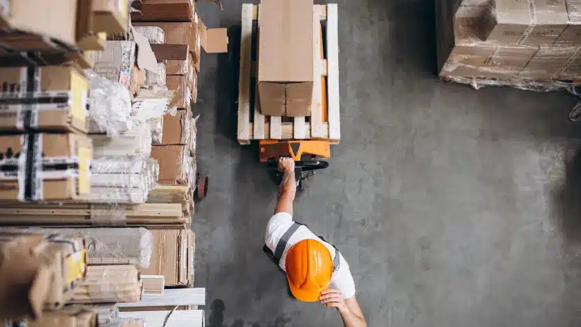 tipos-de-logistica-reversa-funcionario-carregando-mercadoria-com-um-carrinho-no-estoque-da-fabrica