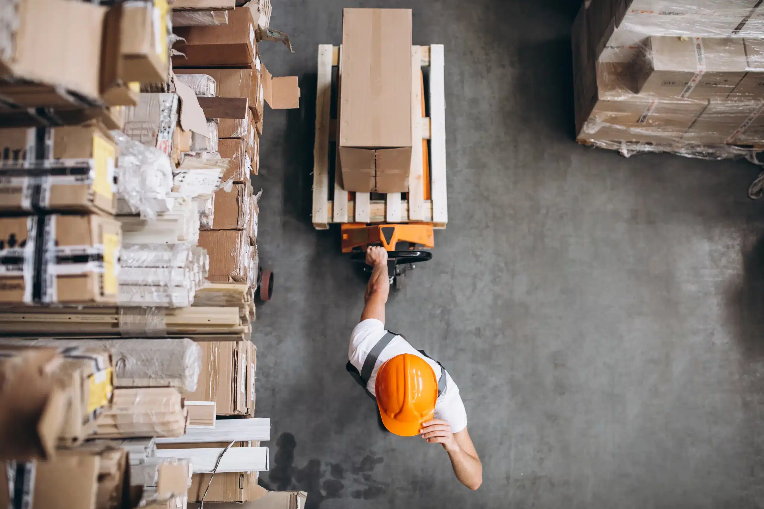 tipos-de-logistica-reversa-funcionario-carregando-mercadoria-com-um-carrinho-no-estoque-da-fabrica