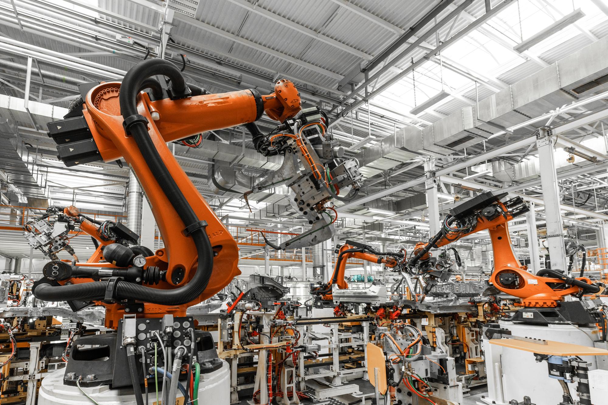 A imagem mostra um sistema avançado de robôs industriais, conhecidos como "pick-and-place", que são utilizados para realizar tarefas de movimentação de peças em linhas de produção automatizadas. Esses robôs são projetados para pegar, transportar e posicionar componentes com alta precisão, otimizando processos na indústria.